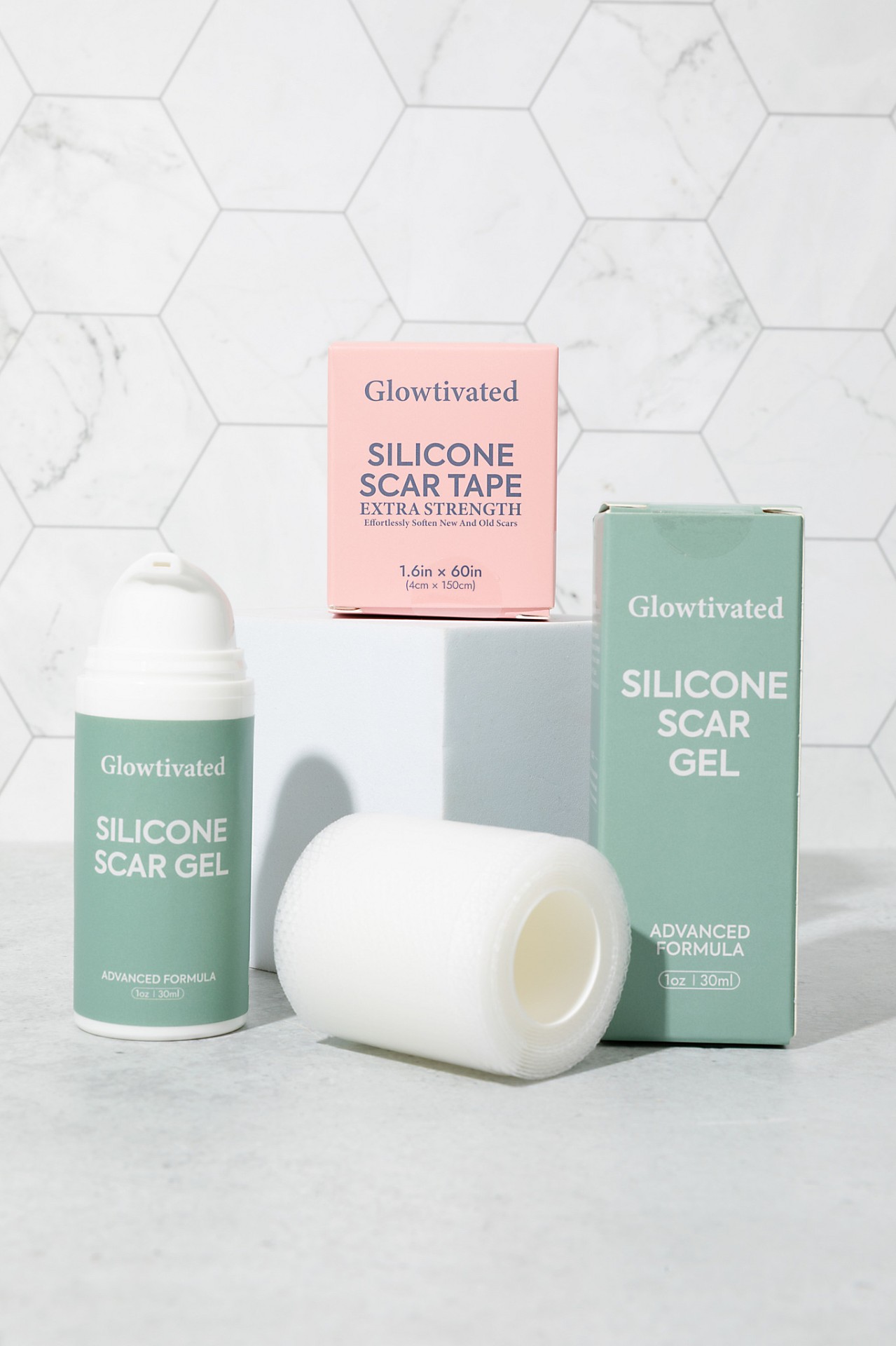 Glowtivated Silicone Scar Gel bottle, sage carton and pink scar tape box arranged on white marble
